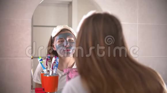 一个年轻漂亮的女人从脸上洗掉了面具视频的预览图