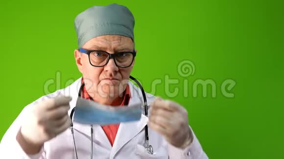 戴医用口罩和带注射器的医用手套的高级成人医生正在准备注射病毒防护视频的预览图