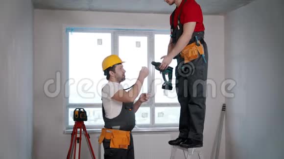 公寓维修一名工人把钻头传给另一名工人视频的预览图