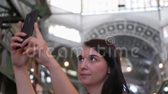 一个漂亮的黑发女人在食品市场上自拍视频的预览图