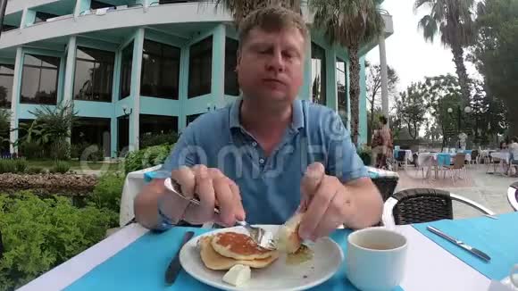 一个男人在街头咖啡馆吃午饭视频的预览图
