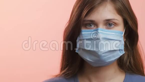 一位年轻女性在摄影棚背景下戴着医用防护面罩白种人女孩防止病毒流行病和疾病的传播视频的预览图