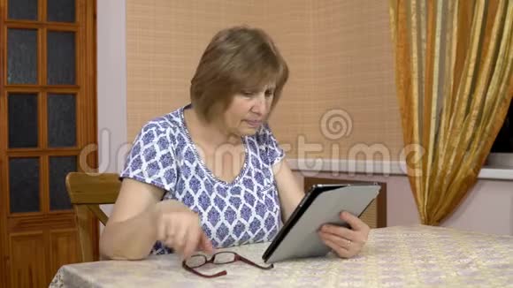 女人第一次使用平板电脑老妇人不明白如何使用药片戳她的手指还有视频的预览图