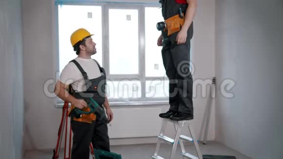 通风房的公寓维修一个工人把钻给另一个工人开始钻天花板视频的预览图