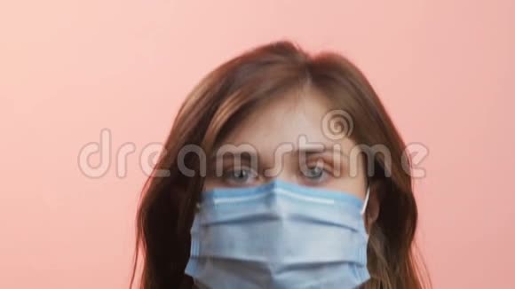 下面是一位戴着医用口罩的年轻女子的头部女孩用手指再次鼓励采取单独的保护方法视频的预览图