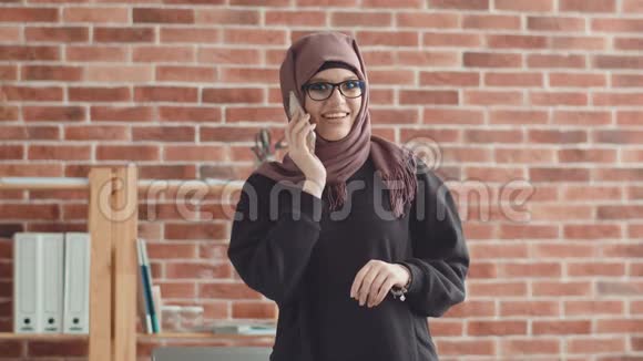 穆斯林女孩戴着头巾和一个朋友通电话视频的预览图