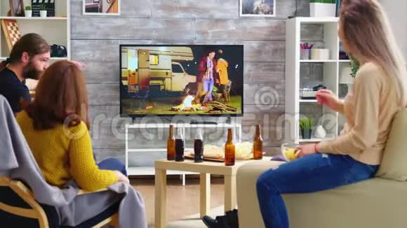 金发女人和她的朋友一起看电视节目的后视图视频的预览图