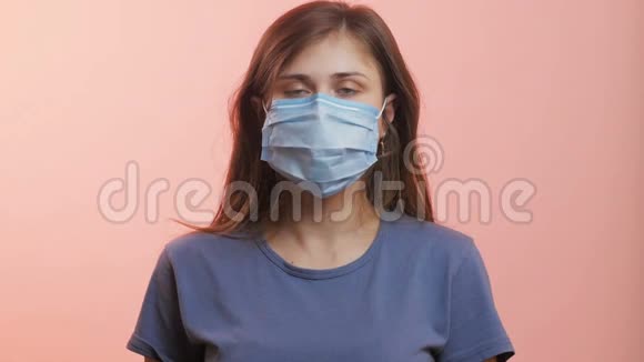 一位年轻女性的头部在工作室背景下戴着医用防护面罩女孩防止病毒传播并表现出良好的姿态epi视频的预览图
