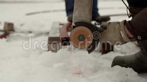 用电锯锯掉金属型材男人手在雪地里用电动工具切断金属型材视频的预览图