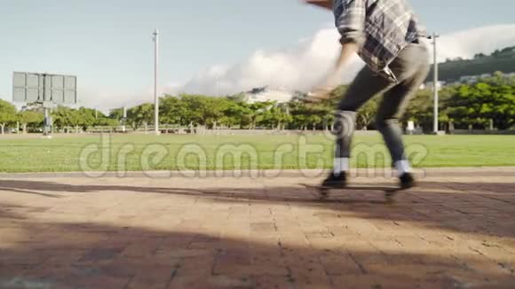 一名男性滑板运动员在公园的滑板上做平衡动作视频的预览图