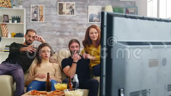 男人一边看电视一边伸手拿啤酒视频的预览图