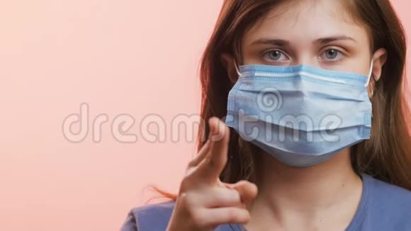 年轻女性呼吸沉重并在工作室背景概念保健个人反应上展示保护性医疗面具视频的预览图