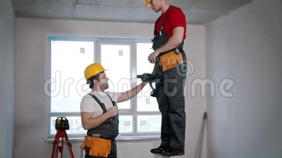两个男工和公寓修理在仪器里放一个钻头视频的预览图