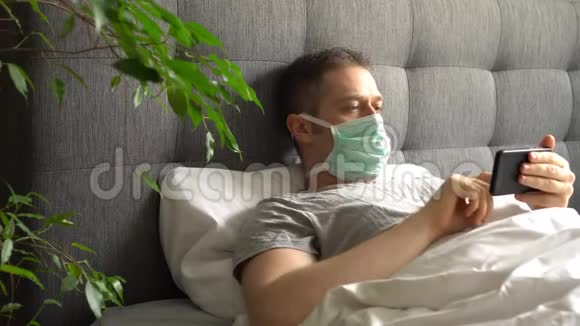 带医疗口罩的病人在床上使用手机视频的预览图
