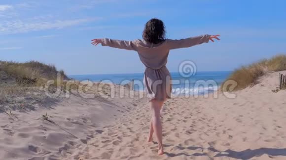 在假日旅行中女人抱着胳膊走到夏日海滩视频的预览图