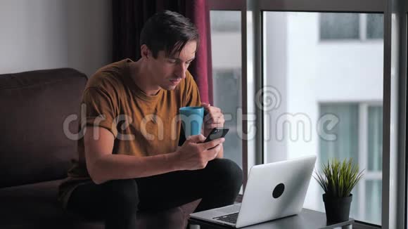 忙碌的人用智能手机和笔记本电脑做电子商务在网上购物坐在沙发上看视频电影视频的预览图