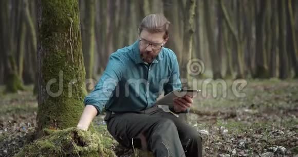 带数字平板电脑的植物学家检查绿苔视频的预览图
