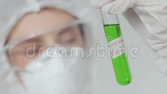 一位年轻的实验室助理检查了一个带有绿色危险放射性物质的试管一个女孩视频的预览图