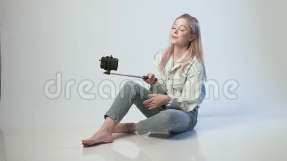快乐女性记录视频为vlog与智能手机连接自拍棒视频的预览图