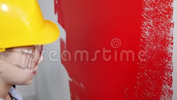 一个小男孩用红色油漆粉刷了一堵墙视频的预览图