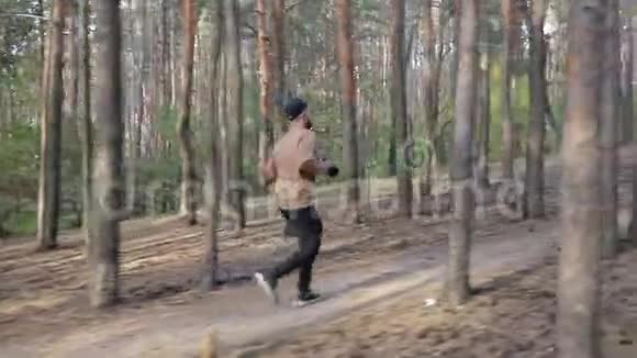 戴着黑色帽子的人手里拿着相机在森林里奔跑视频的预览图