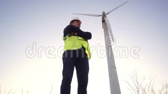 白种人的工程师穿着工作服双臂交叉地站在风车附近视频的预览图