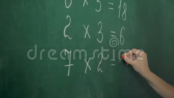 小学老师在教室的绿色粉笔板上写数字视频的预览图