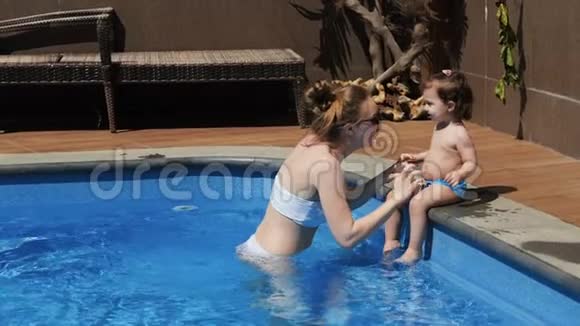 妈妈和小女儿在暑假开放的游泳池里视频的预览图