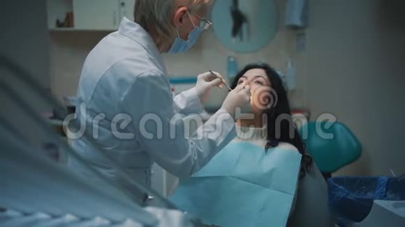 专业牙医女性检查年轻黑发女性牙齿视频的预览图