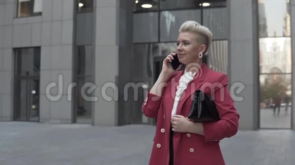 时髦的年轻女人正在电话里进行友好的交谈视频的预览图