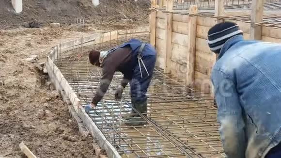 两名工人正在建造一个钢筋框架浇筑混凝土视频的预览图