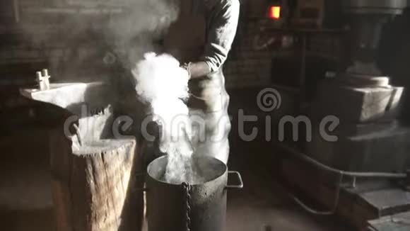铁匠在冷水桶中冷却热的细节视频的预览图