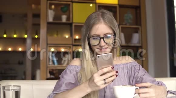咖啡时间女人用智能手机微笑视频的预览图