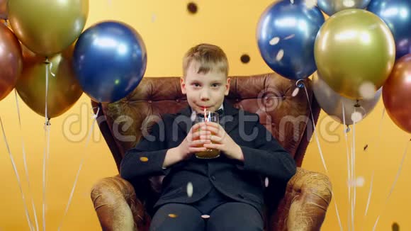 快乐的男孩喝着果汁微笑着满意的男孩庆祝生日视频的预览图