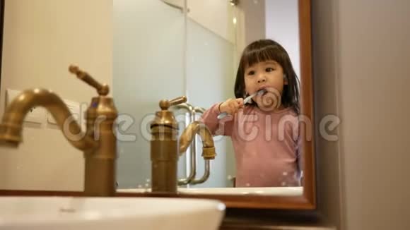 快乐亚洲小女孩早上在浴室刷牙口腔卫生理念视频的预览图