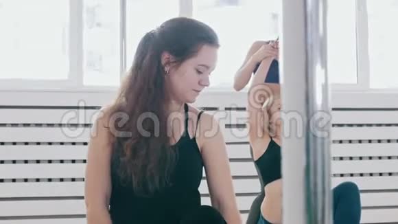 在工作室里做健身运动的女人教练帮助她的学生获得正确的位置视频的预览图