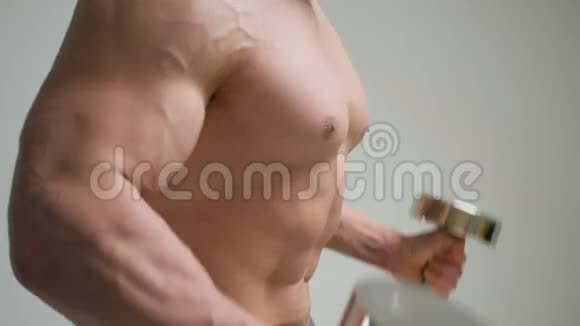 肌肉健美运动员用白色背景的哑铃做运动视频的预览图