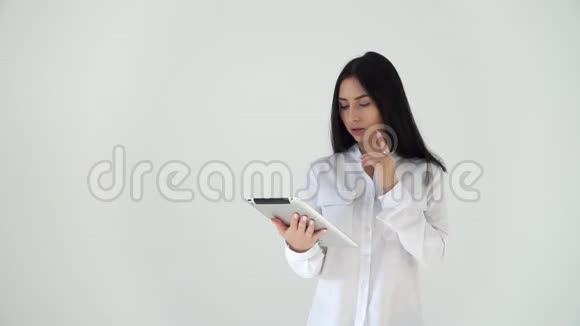 一个体贴的女孩在电脑平板上翻阅新闻一位穿着白色衬衫的商务女士在一个数码公司工作视频的预览图