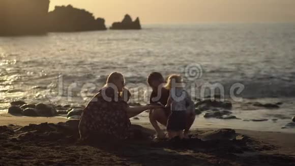 一家四口在海边的沙滩上玩耍视频的预览图