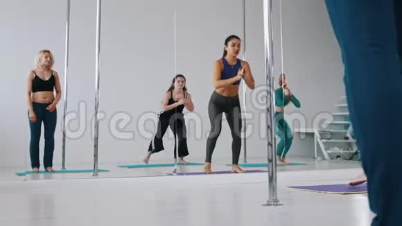 年轻女性在跳舞前在镜子前热身蹲下视频的预览图