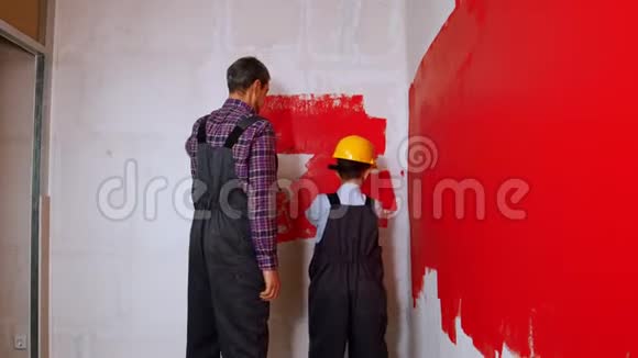 公寓翻新父子一家用红色油漆覆盖墙壁视频的预览图