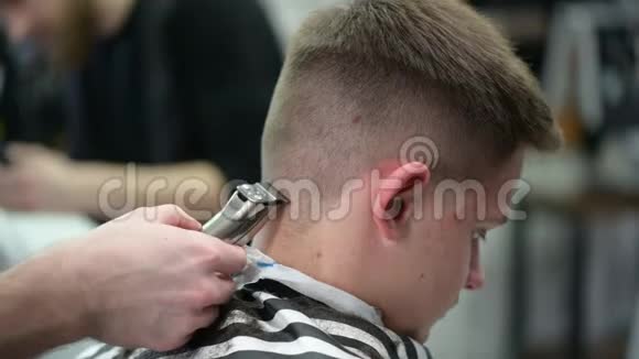 年轻人理发店理发主裁剪头发的特写视频的预览图