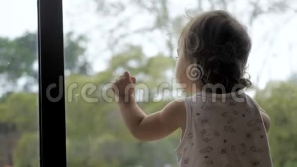 穿着尿布的幼儿站在全景窗的背景上视频的预览图