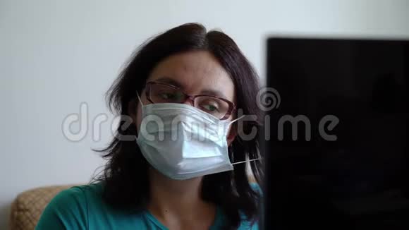 女人在笔记本电脑上读到有关病毒流行的新消息后扔掉口罩看上去轻松自在呼吸愉快视频的预览图