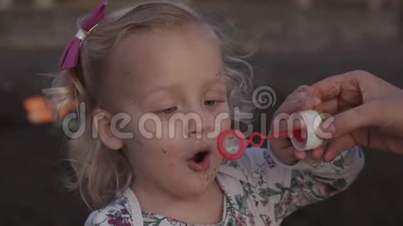 一个正在吹肥皂泡的可爱小女孩的慢动作视频的预览图
