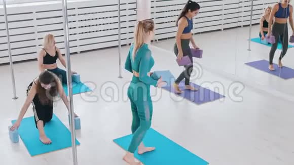 年轻女性在明亮的瑜伽垫工作室健身视频的预览图