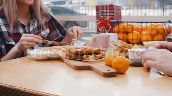 一对夫妇在咖啡馆吃午餐一个女人吃奶酪煎饼视频的预览图