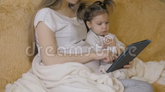 美丽的怀孕女孩和她可爱的小女儿使用数字平板电脑一起度过时光视频的预览图