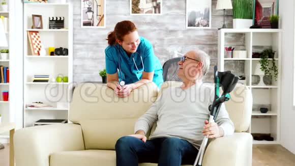 养老院的退休男子和护士谈话视频的预览图