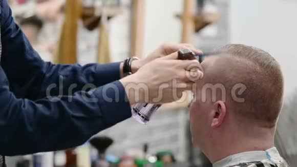 男人理发店理发客户头发的主潮湿梳特写视频的预览图